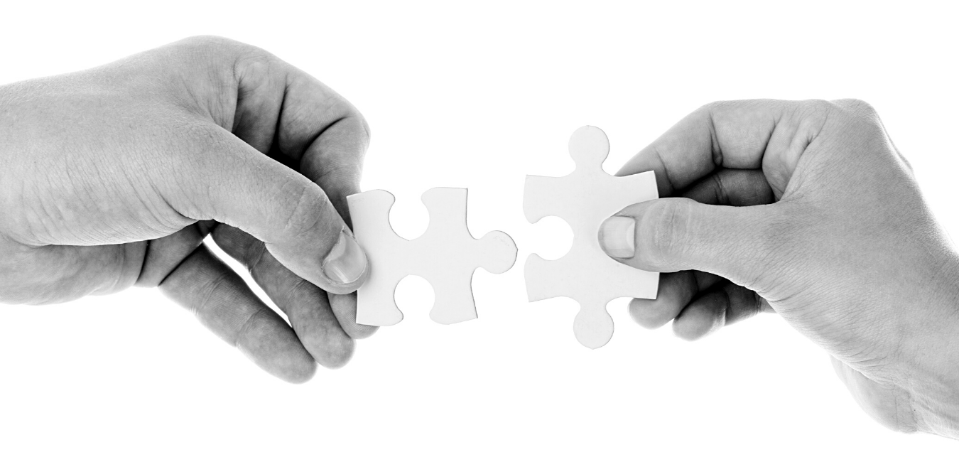Hands holding puzzle pieces connecting